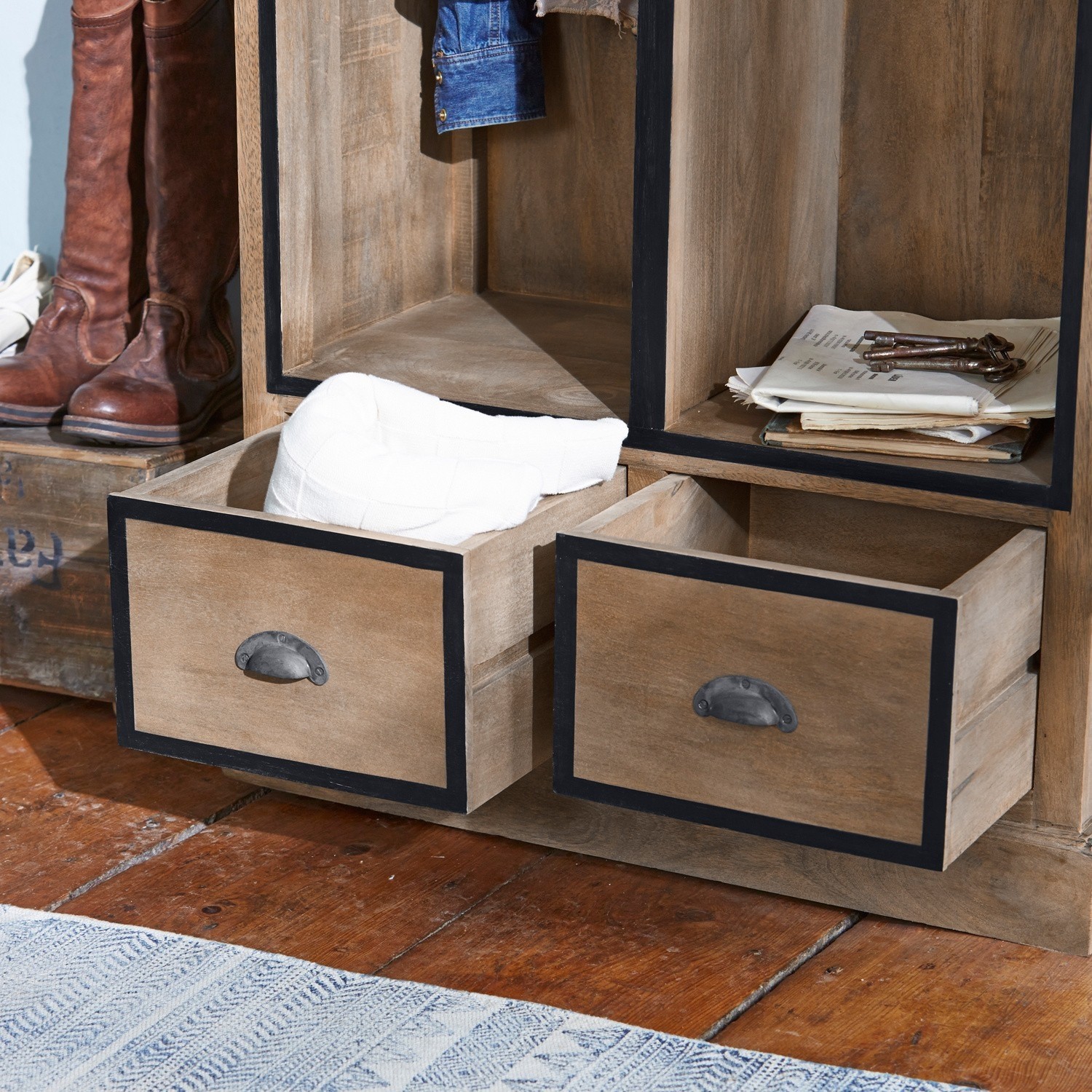 Holzschrank mit zwei offenen Schubladen und Metallgriffen auf Holzboden.