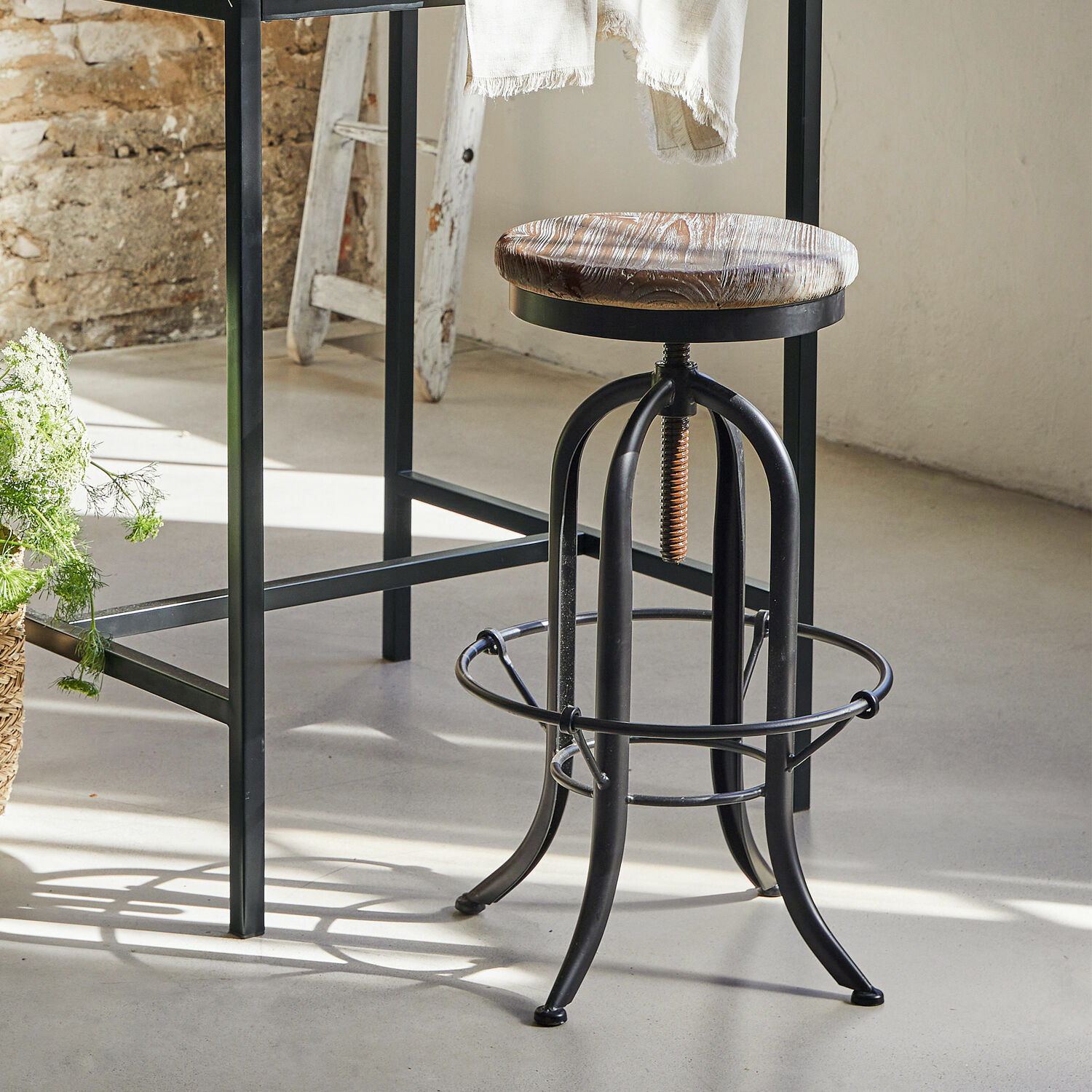 Industrieller Barhocker mit schwarzem Metallgestell und braunem Holzsitz