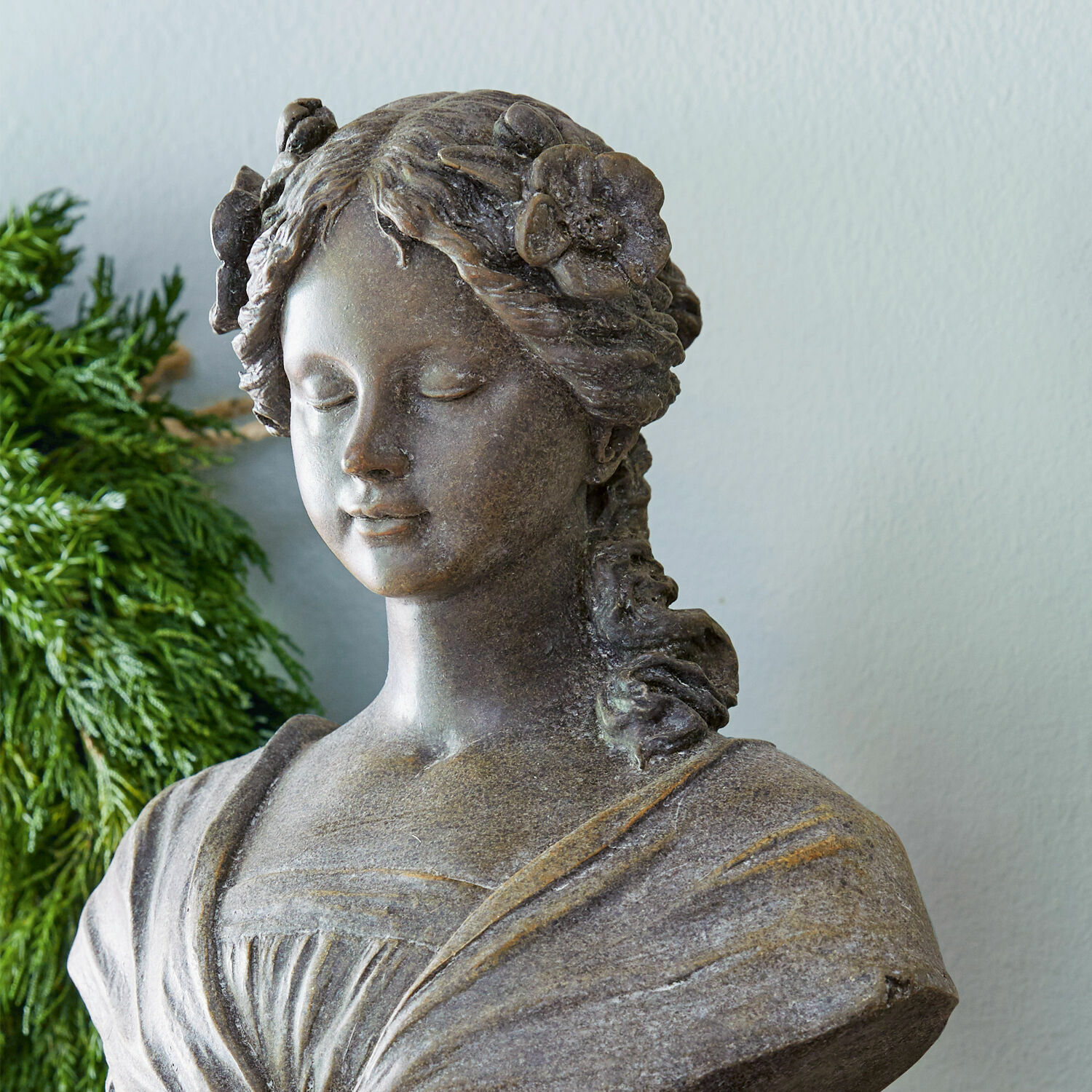 Brustbild einer Frau aus braunem Stein mit Blumen im Haar als Wohnaccessoire
