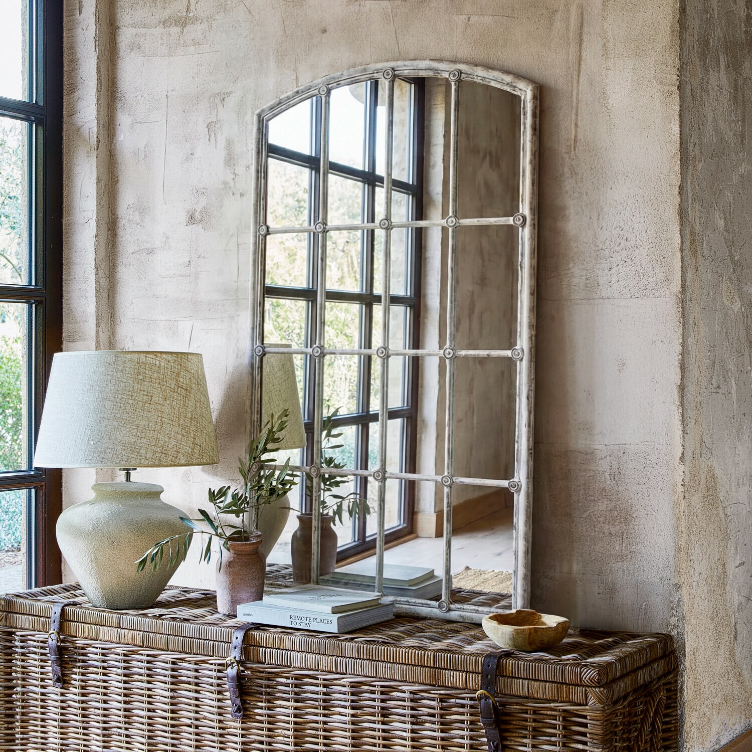 Spiegel Tobiah Spiegel mit weißem Vintage-Rahmen auf Rattankommode mit Lampe und Pflanzendekor im rustikalen Stil