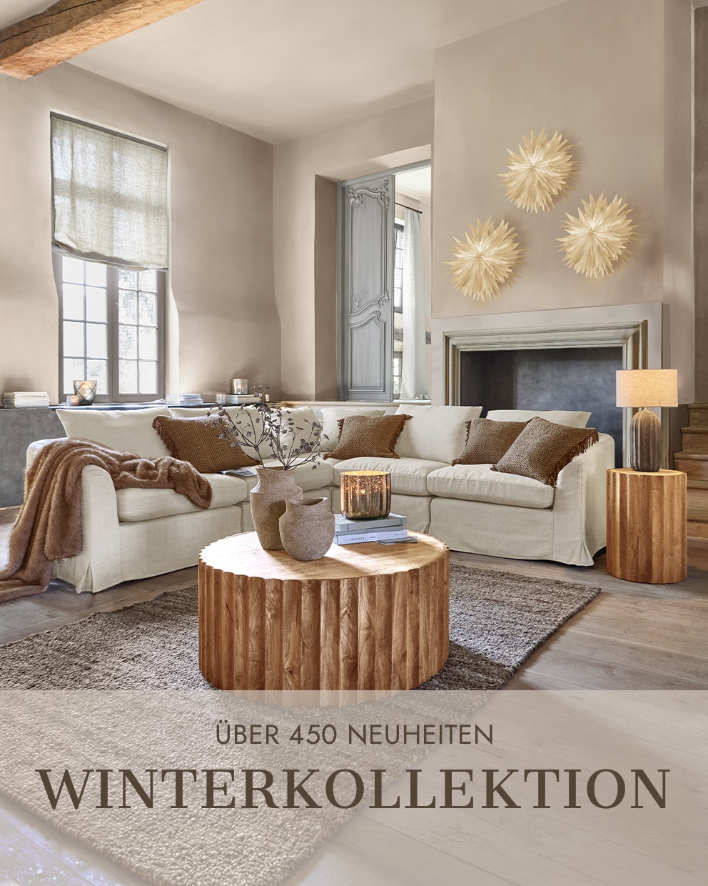 Gemütliches Wohnzimmer mit beigem Sofa, Holztisch und Wanddekorationen aus der Winterkollektion
