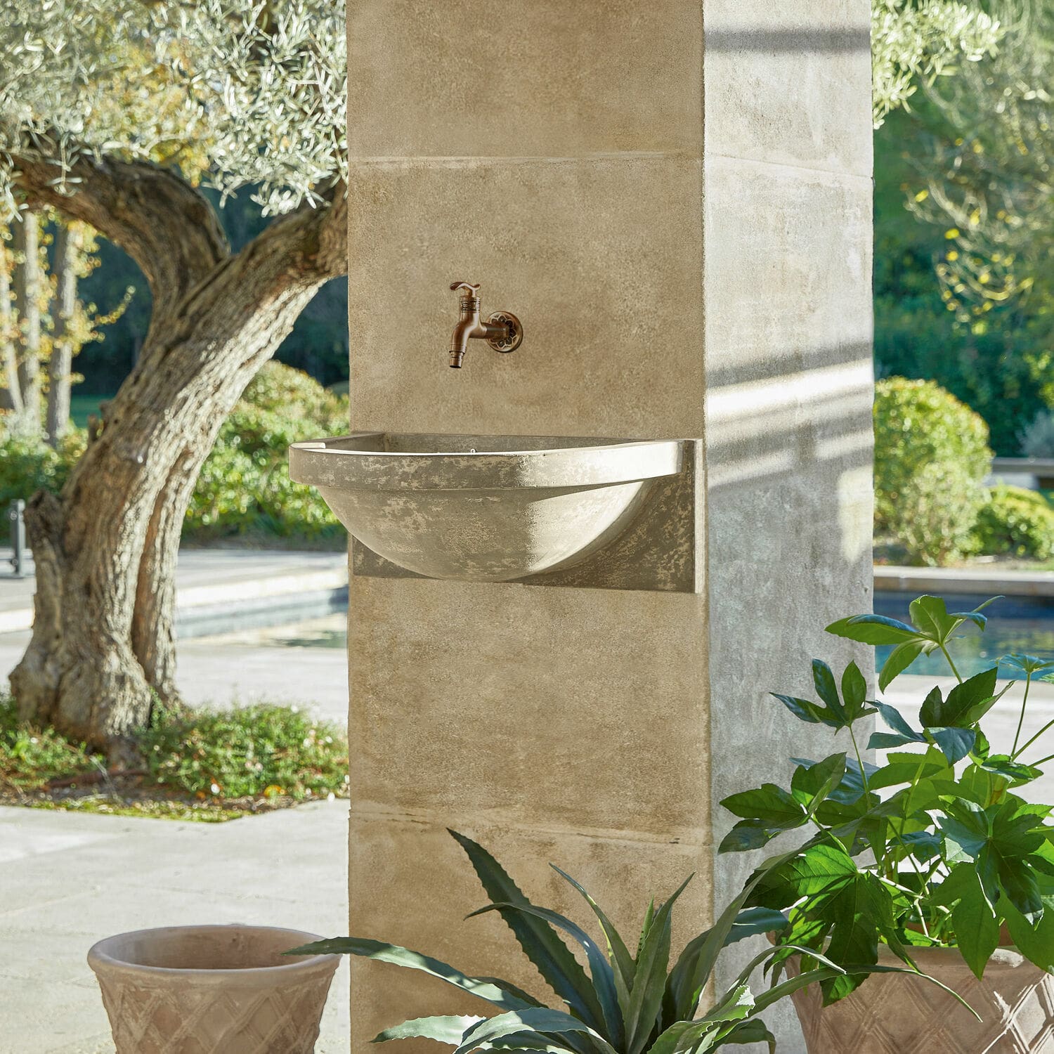 Beige Beton-Wandwaschbecken mit Messinghahn, dekorativ für den Außenbereich im Garten