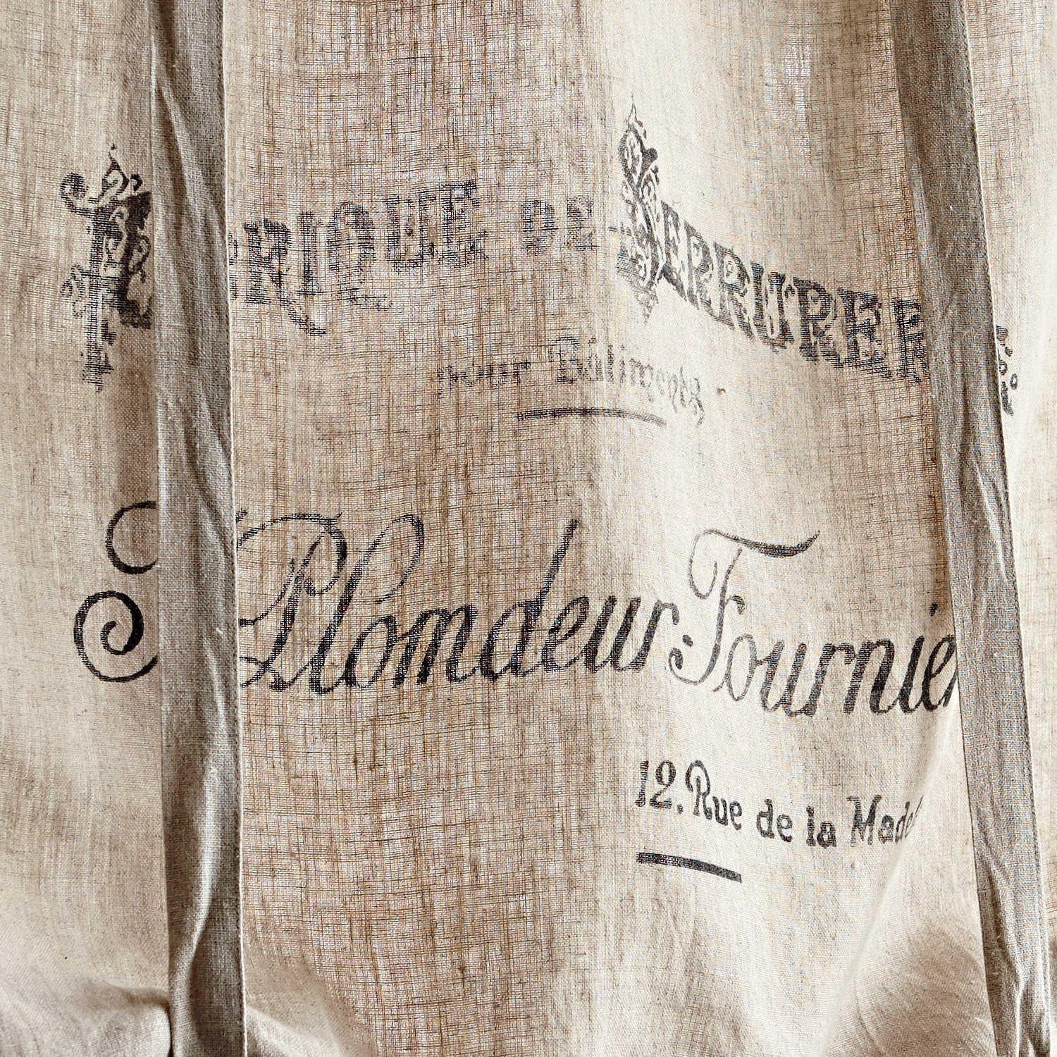 Beiger Leinenstoff mit schwarzem Vintage-Druck und französischem Schriftzug als Dekoration