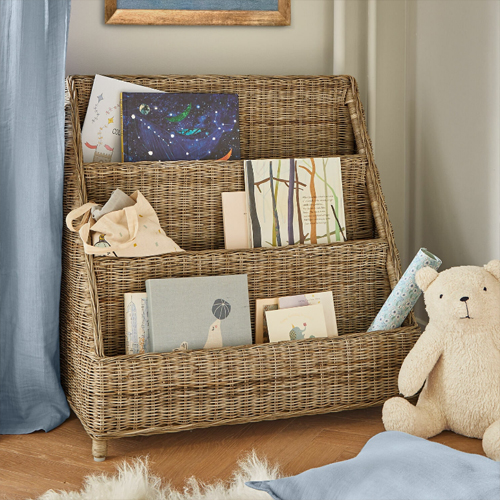 Dreistufiges Regal aus natürlichem Rattan mit Büchern und Plüschbär im Kinderzimmer