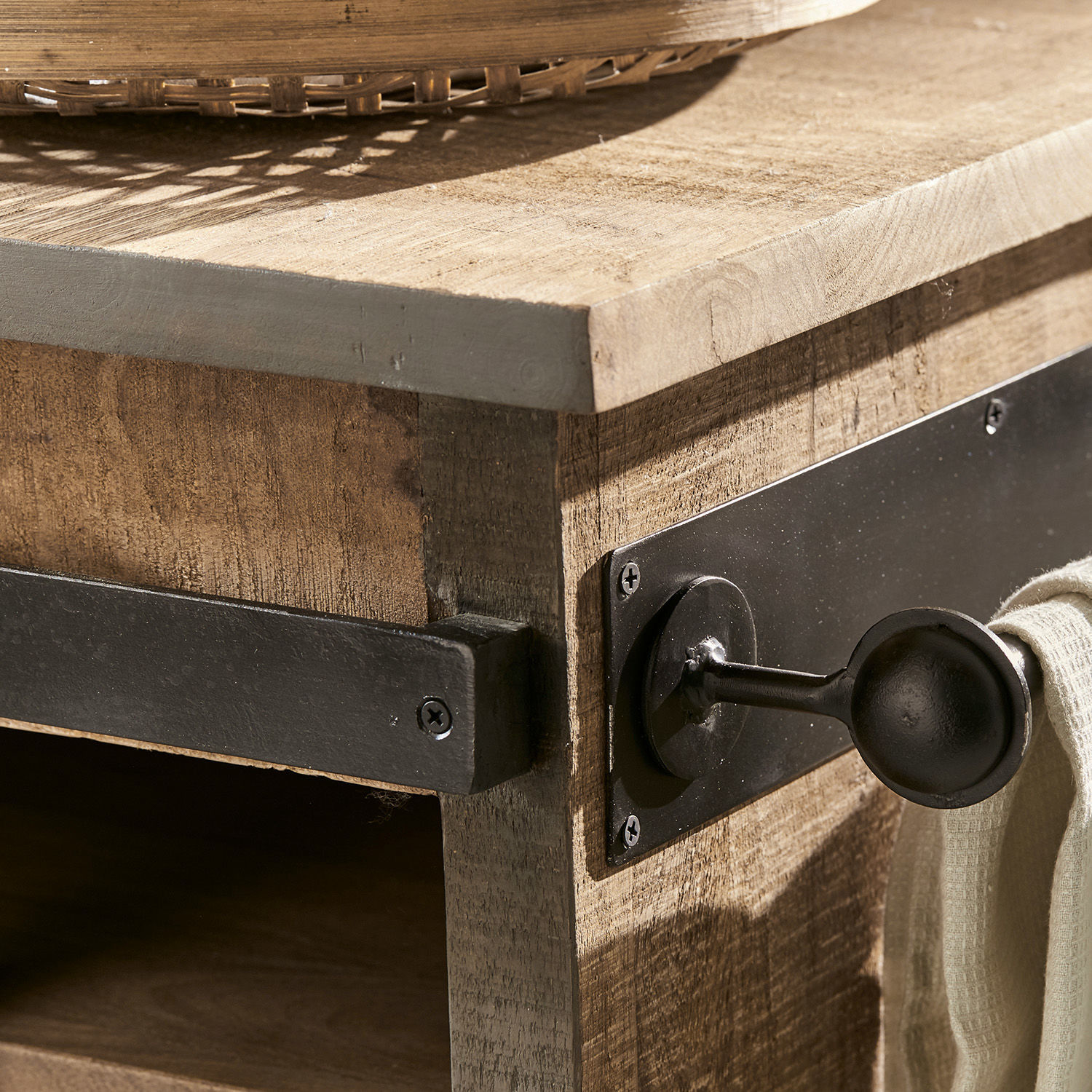 Nahaufnahme eines Holzmöbels mit schwarzem Metallgriff und Handtuchhalter im Industriestil