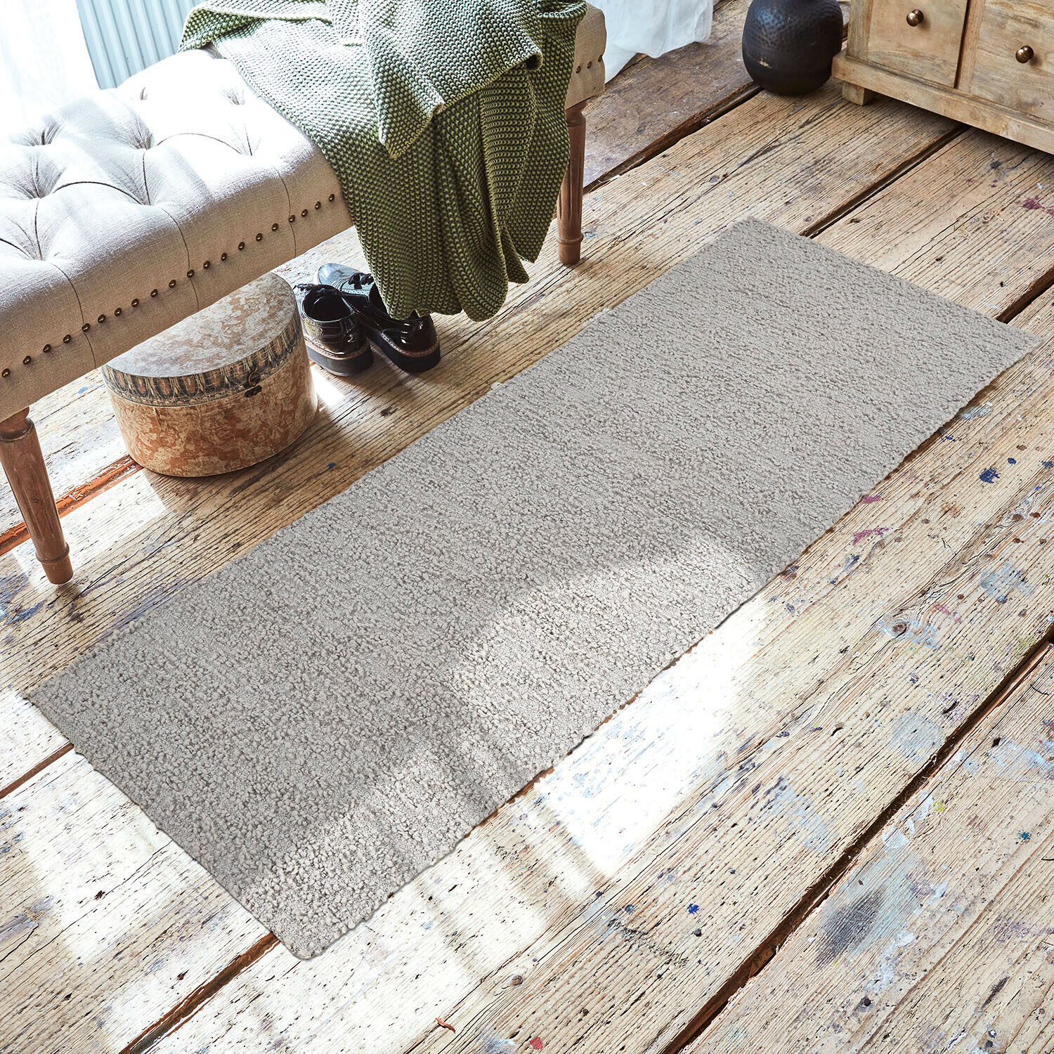 Läufer Kaleema Grauer Teppich aus weichem Material auf Holzboden in gemütlichem Raum mit Bank und grünem Plaid