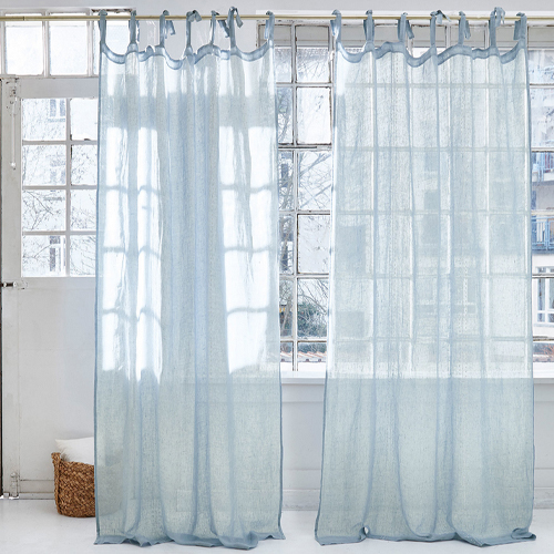 Leichte, hellblaue transparente Vorhänge aus feinem Stoff vor großem Fenster im modernen Raum.