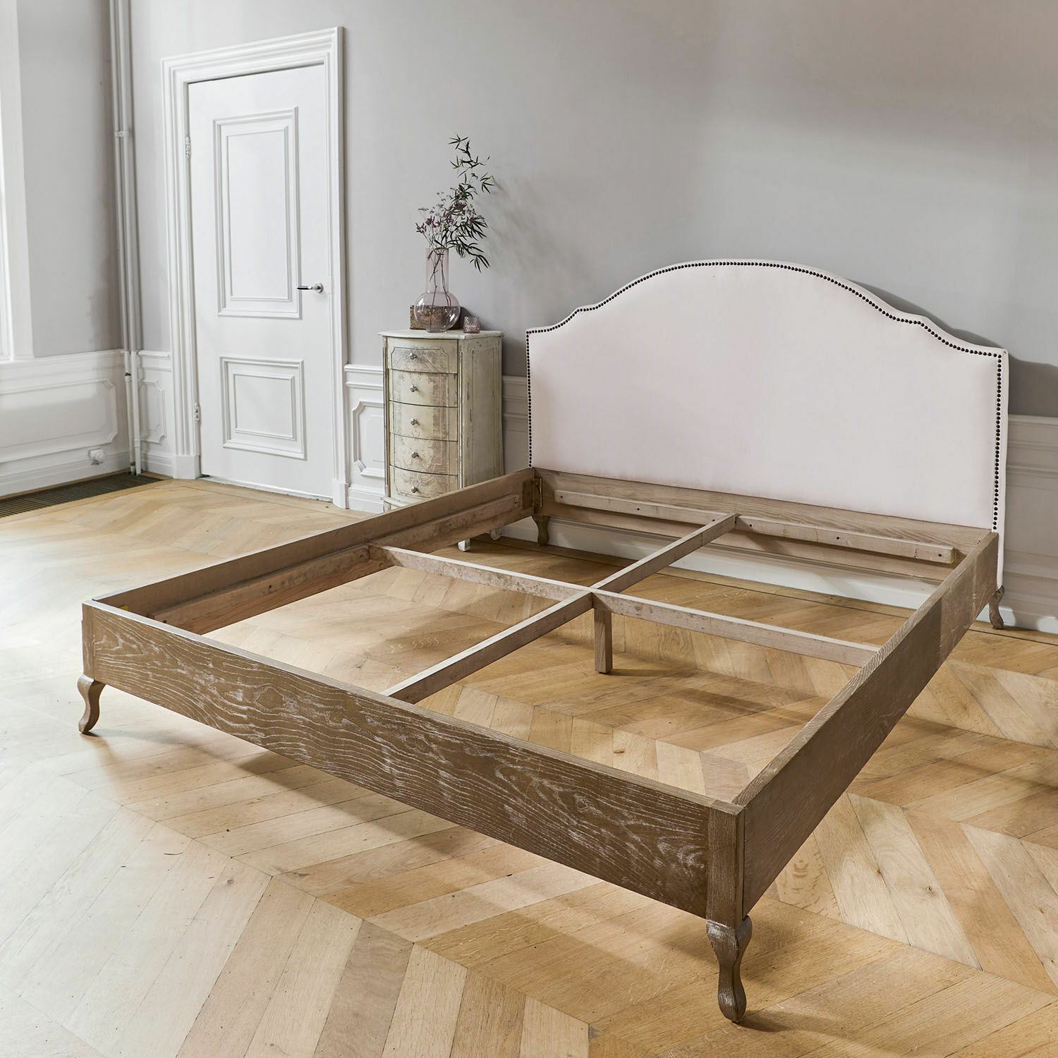 Bettgestell aus Holz mit hell gepolstertem Kopfteil und natürlicher Eichenoptik im Schlafzimmer
