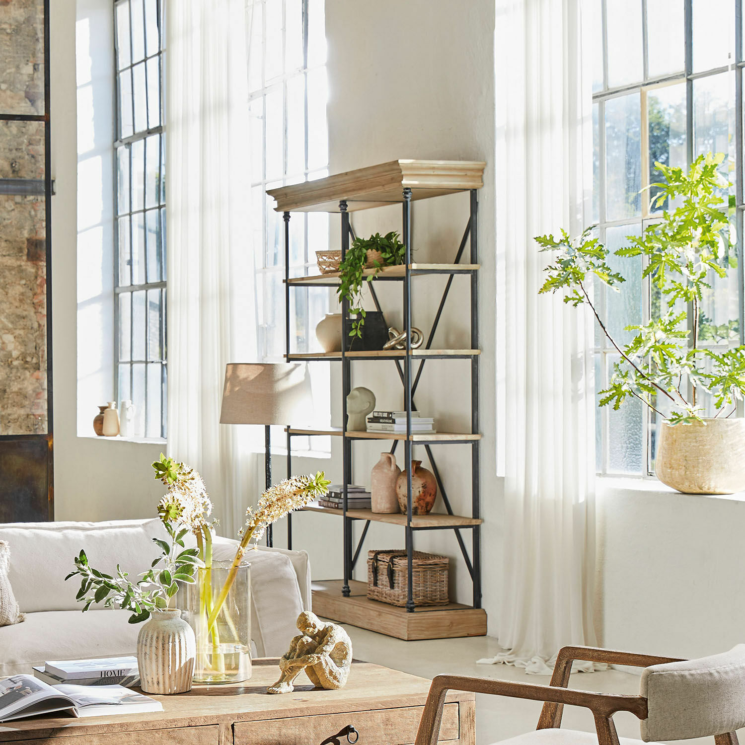 Eckregal aus Holz und Metall im hellen Wohnzimmer mit Dekorationen und Pflanzen im Industrie-Stil