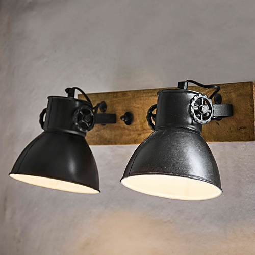 Schwarze Metall-Wandleuchte mit zwei Schirmen auf Holzplatte im Industrie-Design