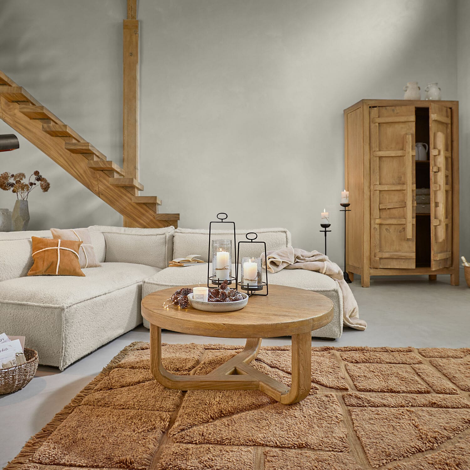 Teppich Volemar Wohnzimmer mit beigem Sofa, rundem Holztisch und warmbraunem Teppich, modernes Interieur mit Naturmaterialien