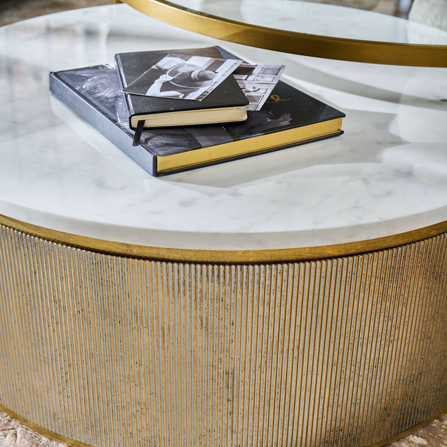 Runder Couchtisch mit weißer Marmorplatte und goldfarbenem Metallgestell, Bücher darauf