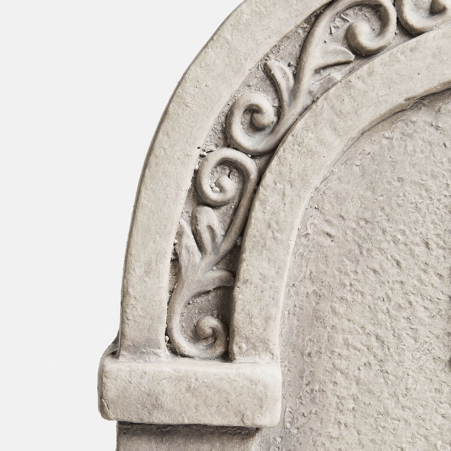 Dekorativer Bogen aus hellgrauem Stein mit pflanzlichem Relief und rustikaler Struktur